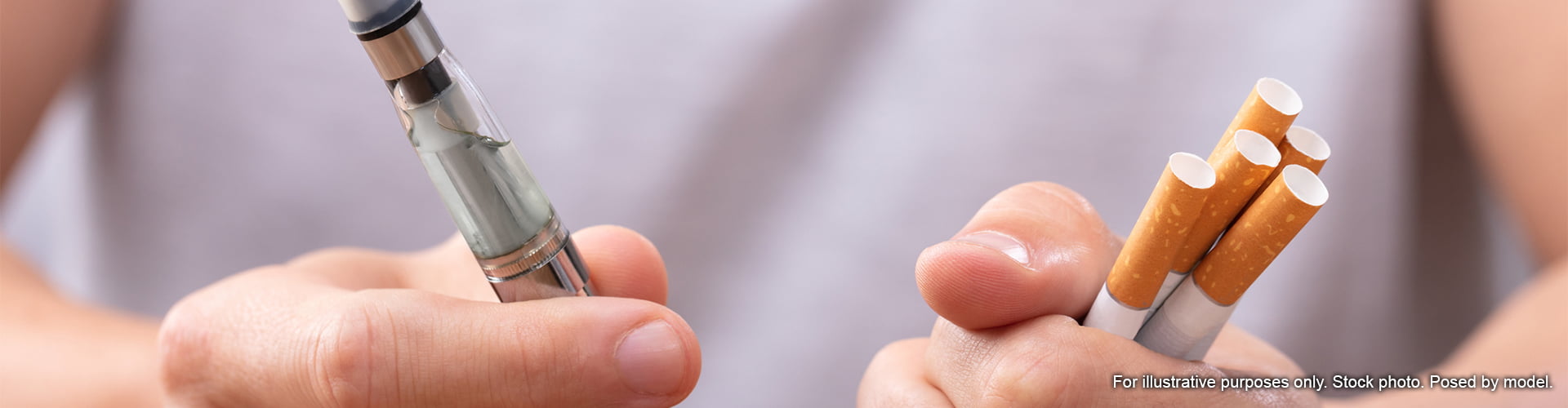 Man holding vape and cigarettes to compare them